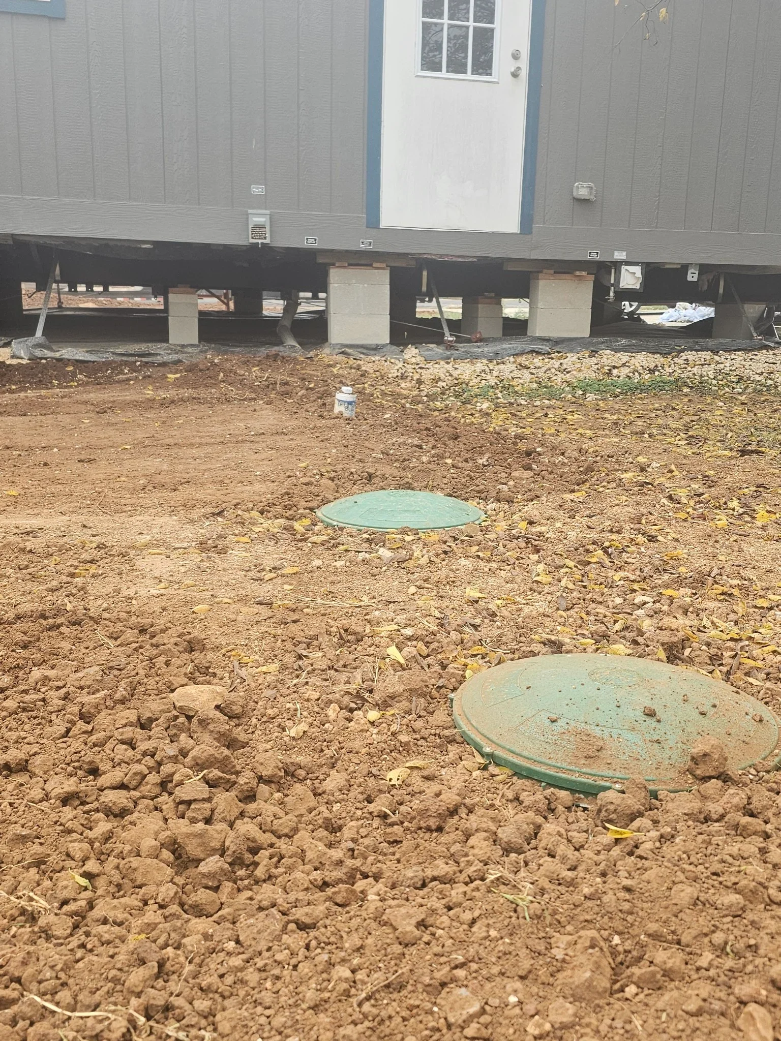 Septic system installation with green access covers on prepared soil foundation